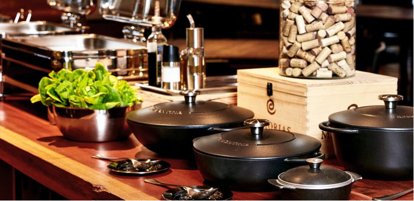 Black sauce pans with lids on a table.