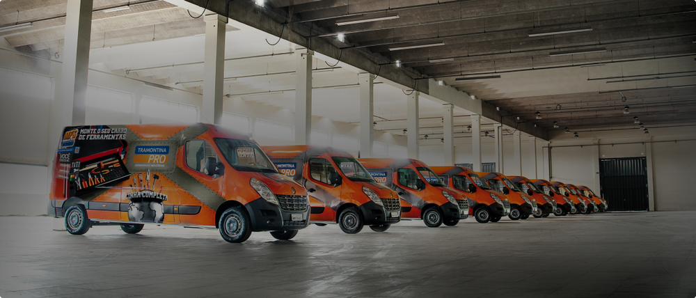 Estacionamento com várias vans da Tramontina PRO estacionadas.