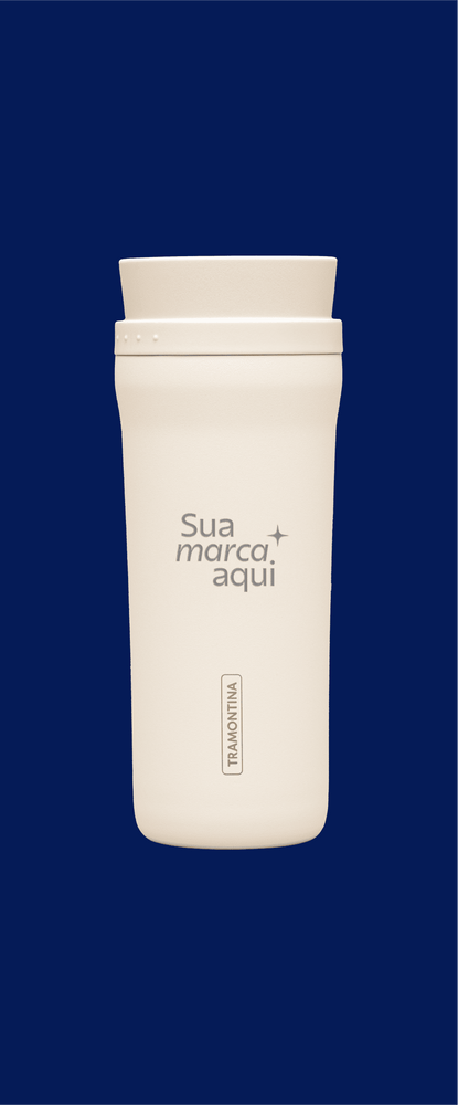 Copo térmico Tramontina na cor off-white, centralizado sobre um fundo azul marinho. O copo apresenta uma simulação de gravação personalizada com o texto 'Sua marca aqui' e um detalhe de estrela. Na base, aparece o logotipo vertical da Tramontina.