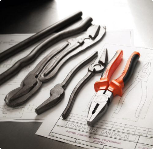 Steel pieces representing the stages of forming pliers. Next to it, a Tramontina PRO pliers.