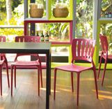 Ambiente con una mesa negra y sillas rojas. 